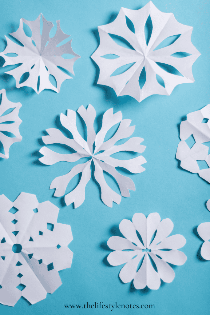 Screen-Free Winter Activities for Kids. White paper snowflakes on light blue background.