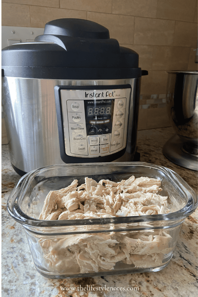 Instant Pot on kitchen counter with a glass container of shredded chicken.