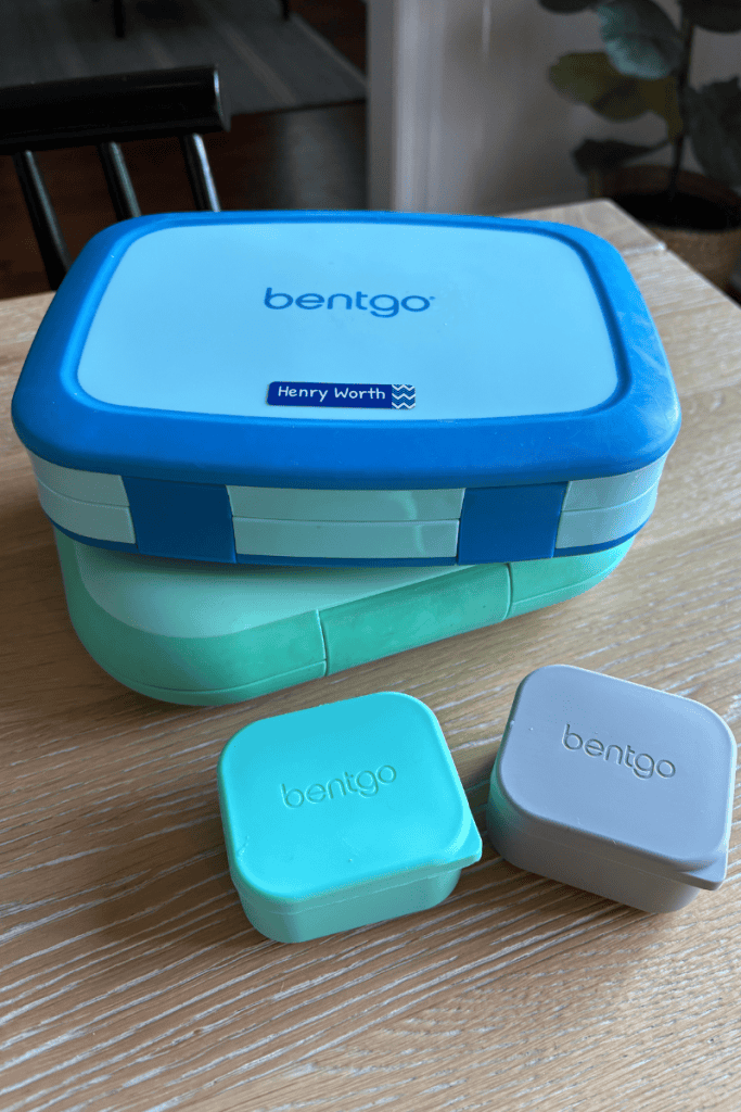 Bento Box Lunch Ideas for Kids. Two bento boxes stacked on table with two small snack/dip containers.