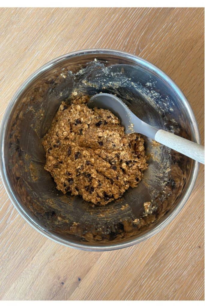 Mixing bowl with gluten free breakfast cookie dough and wooden spoon.
