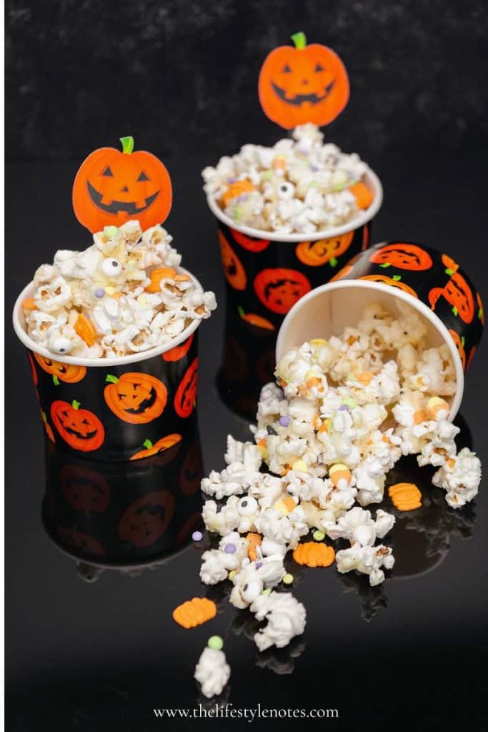 Halloween Movie Night Ideas. Small pumpkin cups filled with a Halloween popcorn mix.